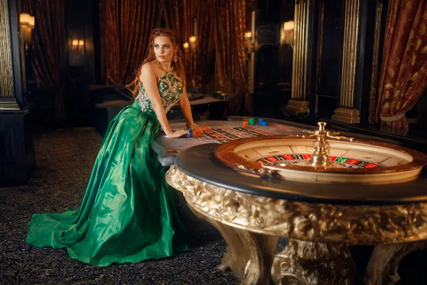A woman in a luxurious green gown next to an ornate roulette wheel, capturing the upscale casino mood of UUOK.